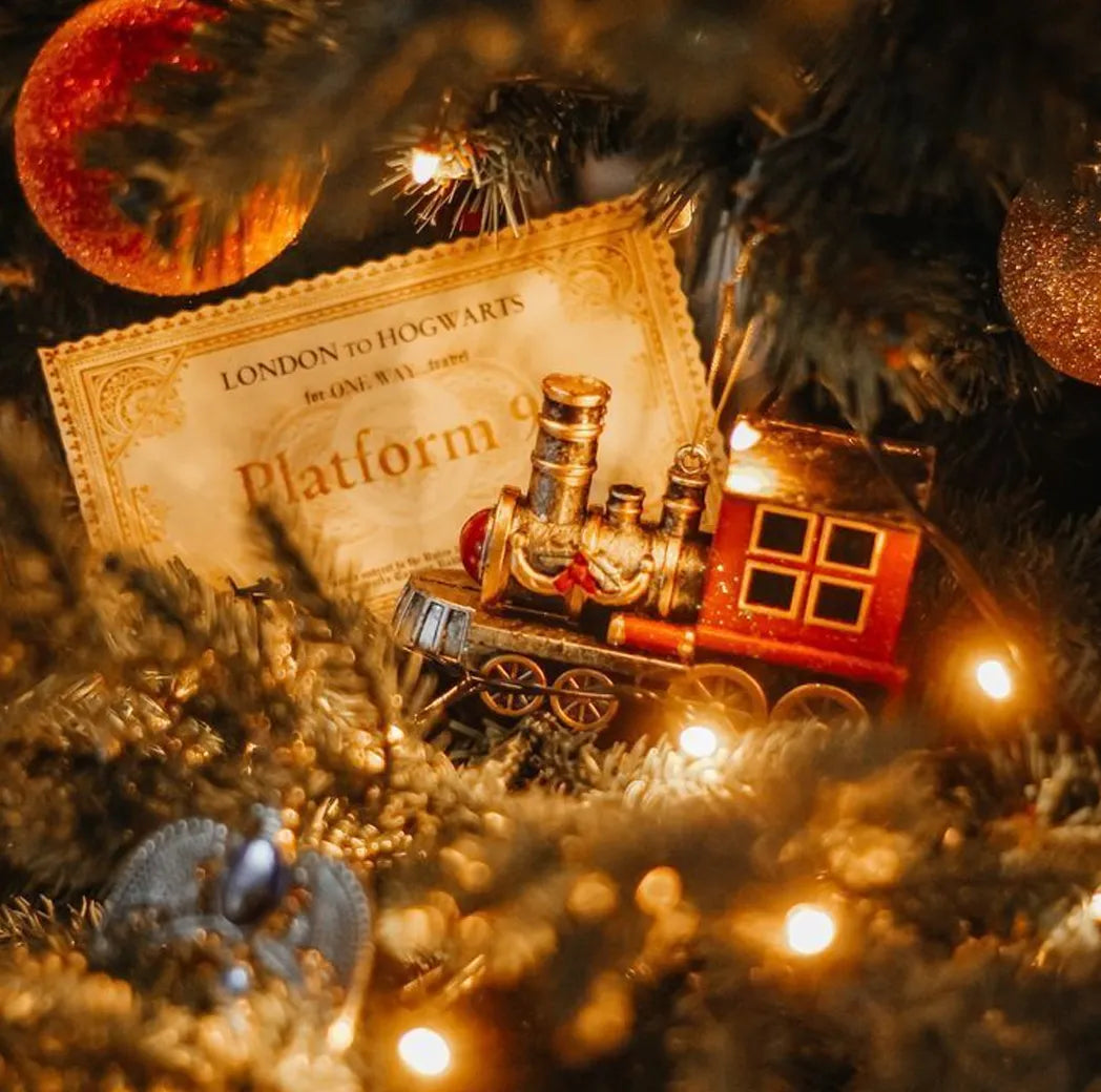 Decorative train set on a Christmas tree with lights and ornaments.