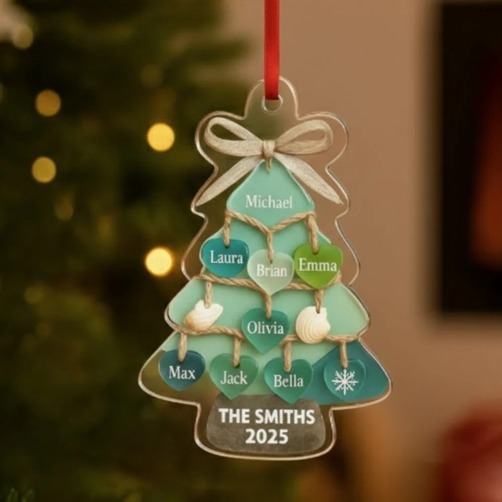 Personalized Christmas tree ornament with names and year, hanging against a blurred festive background.