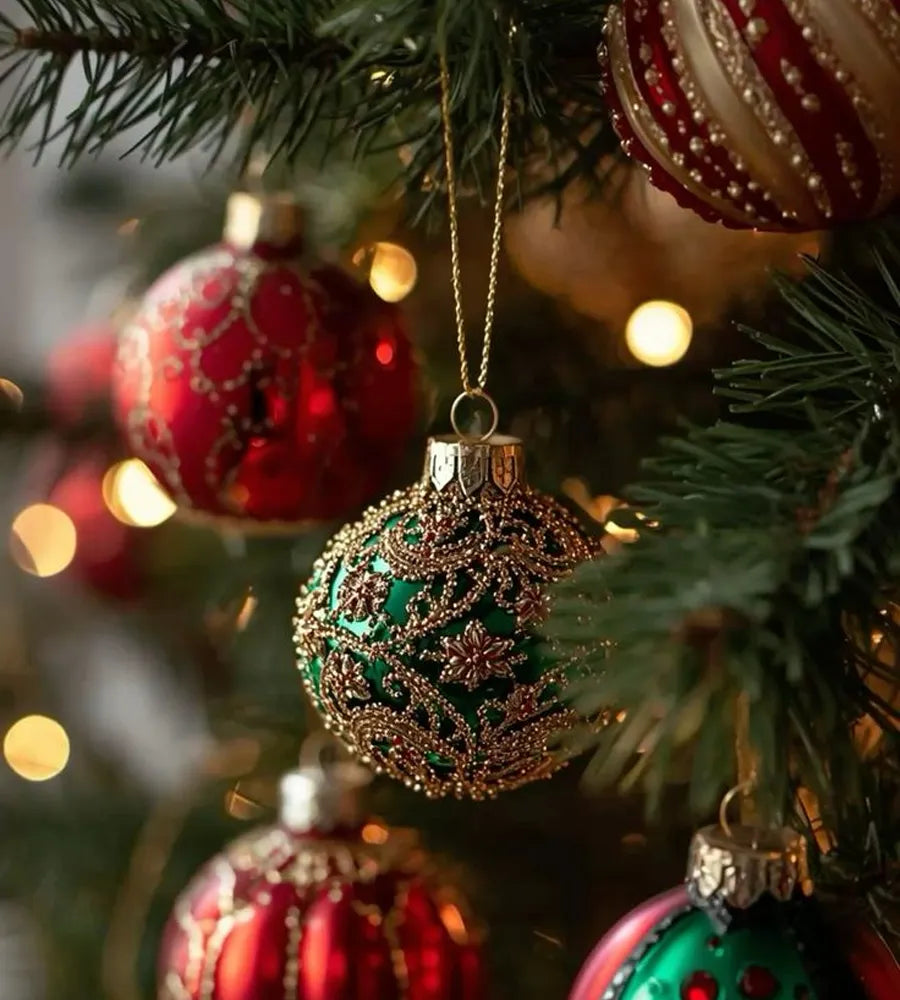Decorative Christmas ornaments on a tree with blurred lights in the background